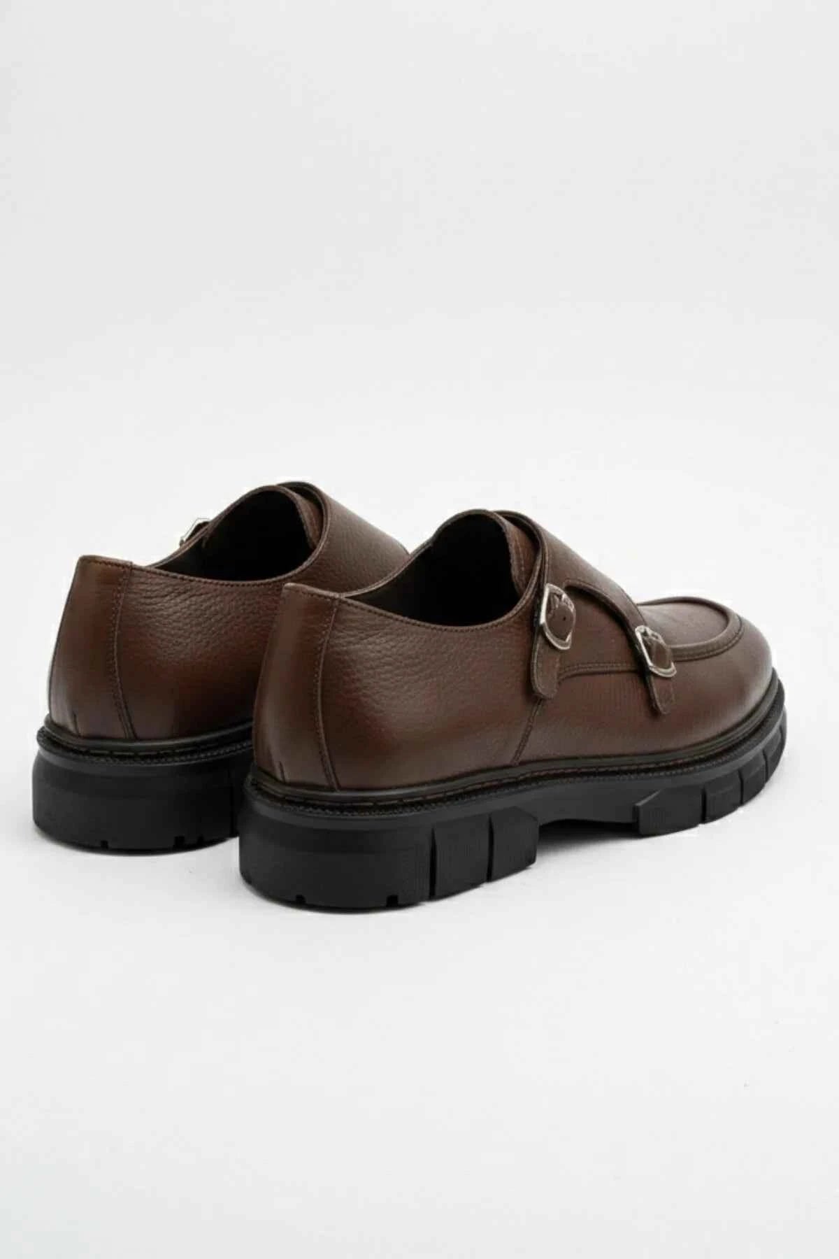 Brown leather double-buckle loafers shown from heel, black outsole