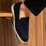 Navy leather loafer close-up with strapless slip-on upper and white sole