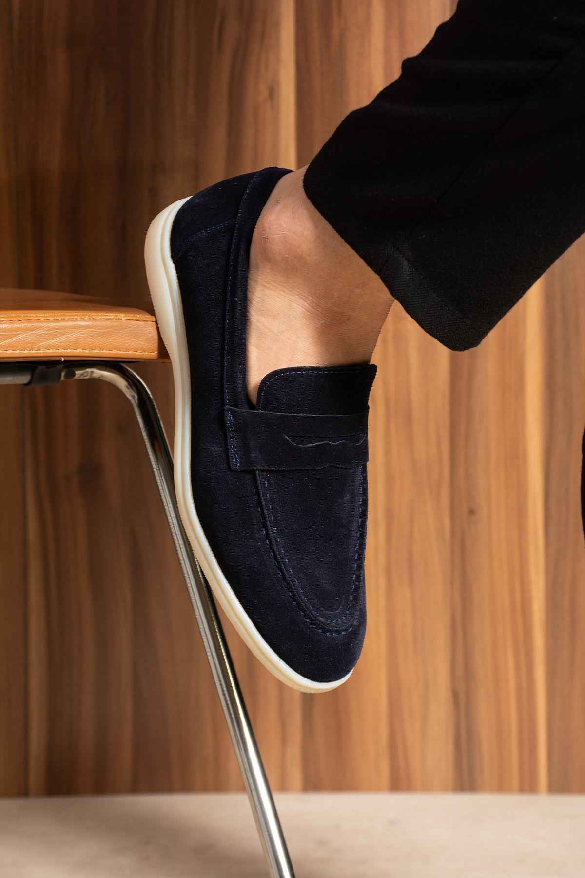 Navy leather loafer close-up with strapless slip-on upper and white sole