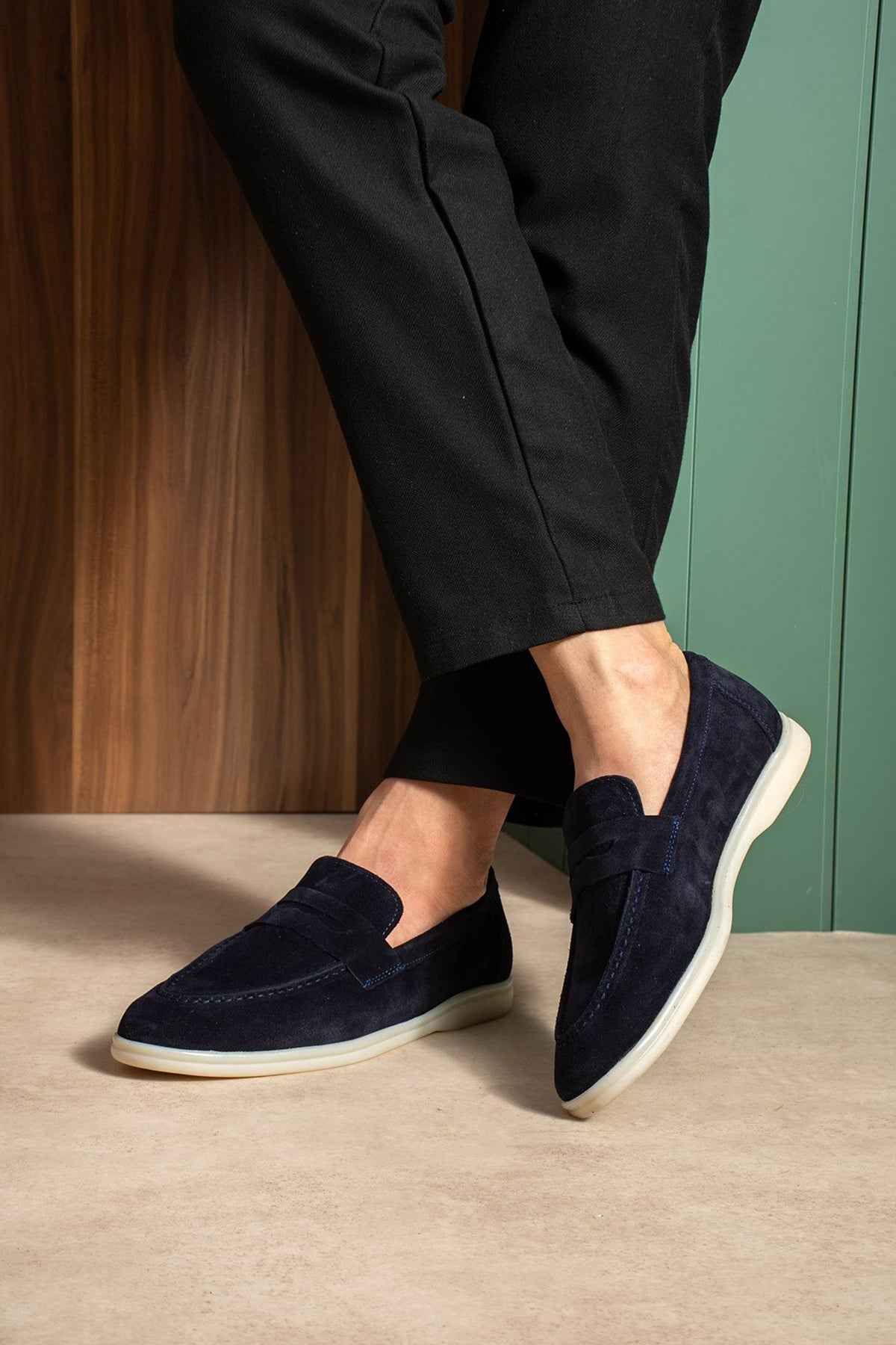 Navy leather slip-on loafers with textured upper and white rubber sole