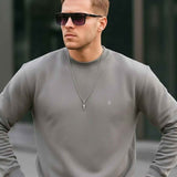Men's gray crewneck sweatshirt with long sleeves and ribbed hem, small chest logo