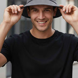 Gray bucket hat held by brim, wide round crown