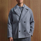 Gray oversized double-breasted coat with notch lapels, black buttons, flap pockets