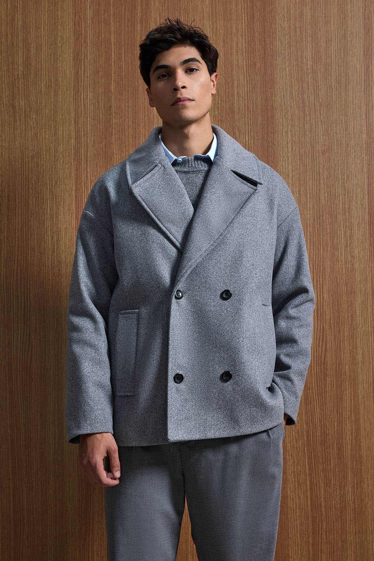 Gray oversized double-breasted coat with notch lapels, black buttons, flap pockets