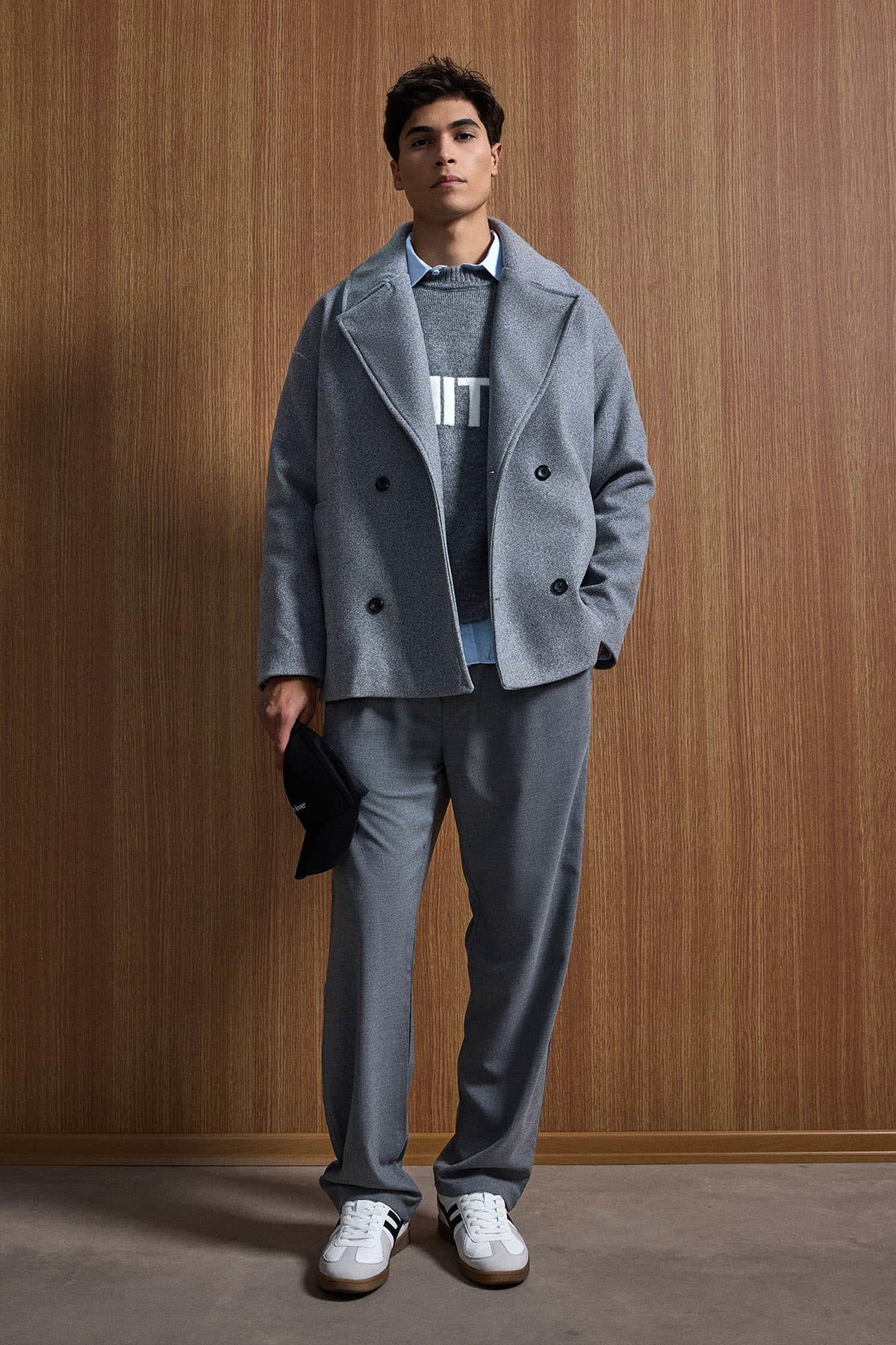 Gray oversized double-breasted coat with notch lapels, black button closure, flap pockets