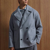 Gray oversized double-breasted coat with structured notch lapels and black button closure