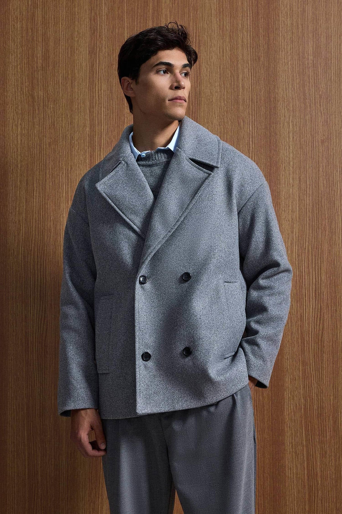 Gray oversized double-breasted coat with structured notch lapels and black button closure