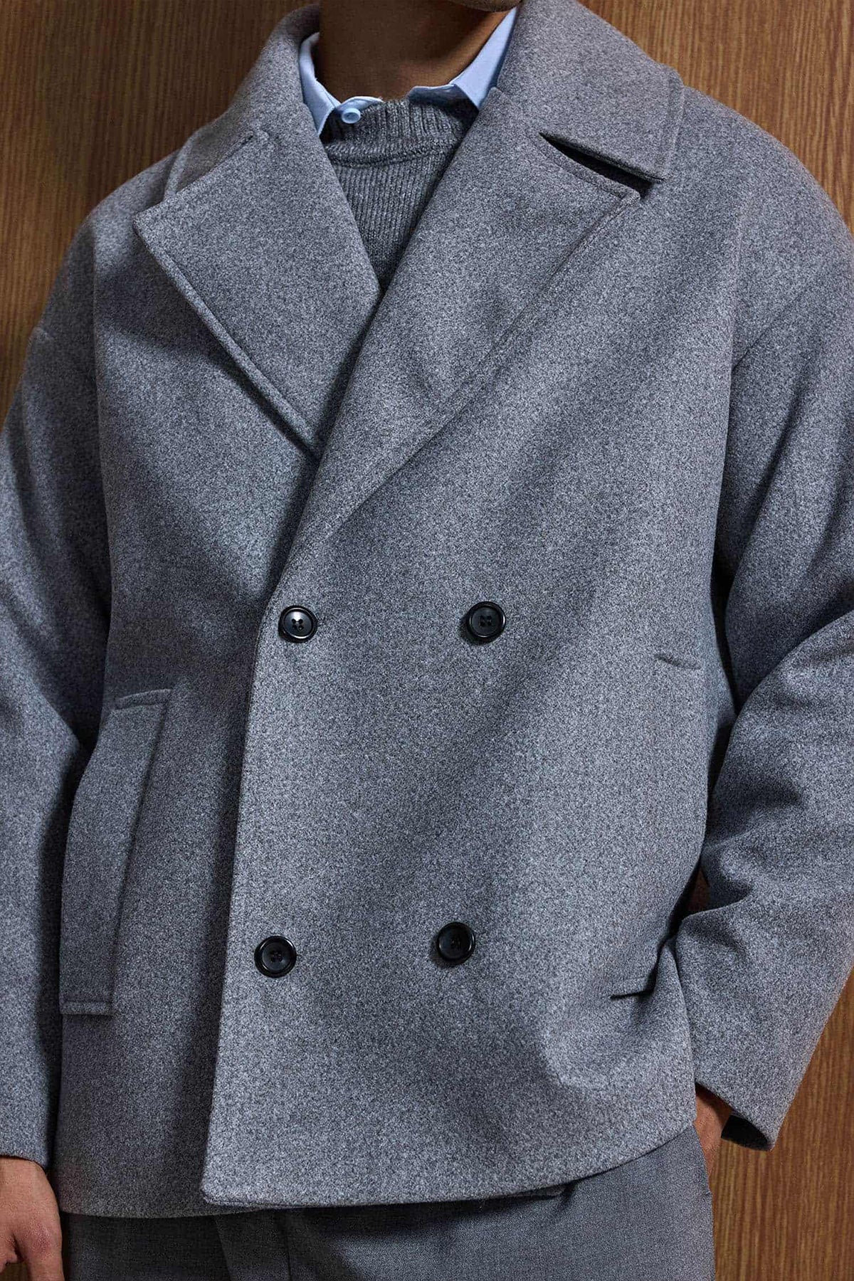 Gray double-breasted coat front with notch lapels and black button fastening