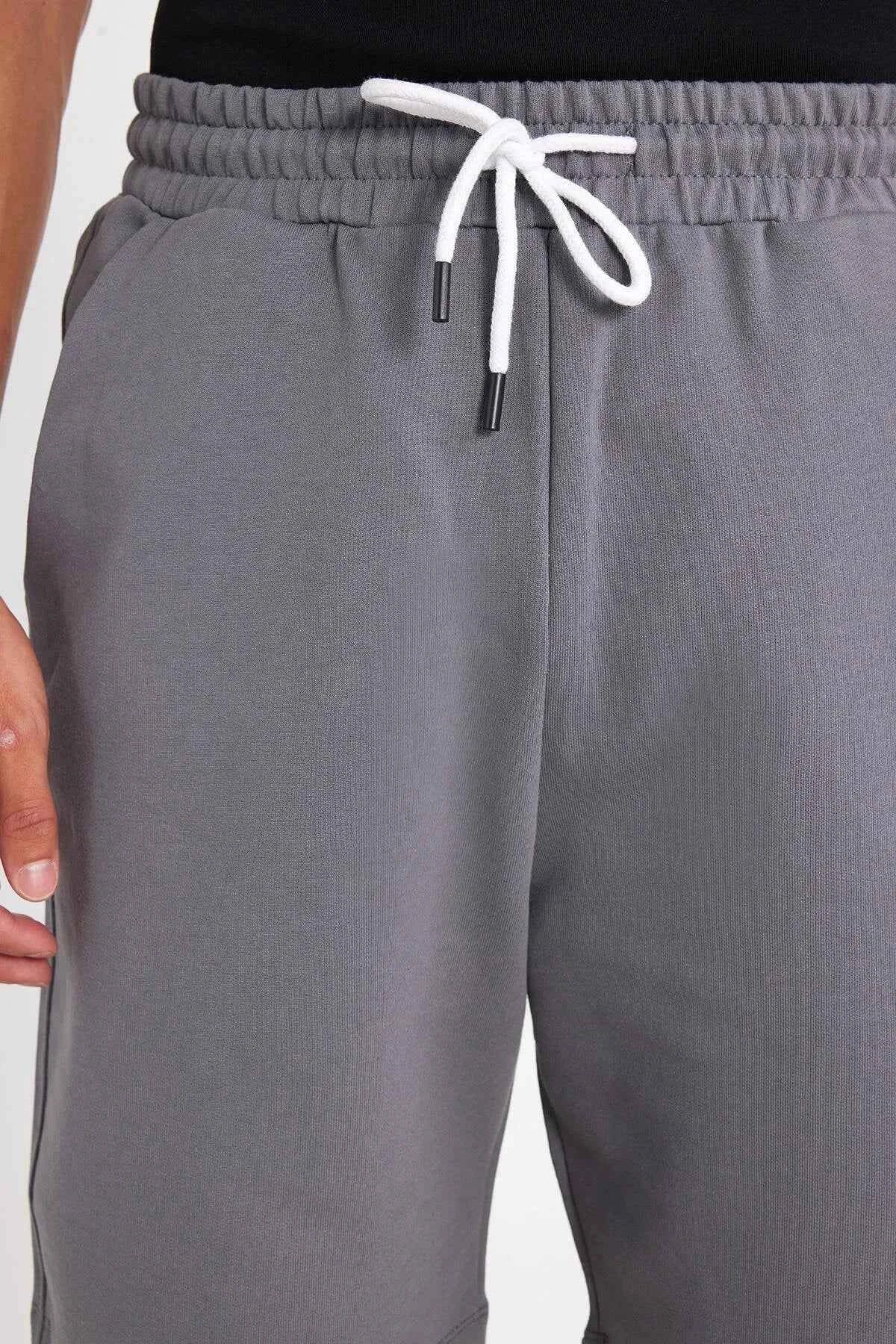 Men's gray shorts with elastic waistband and white drawstring close-up