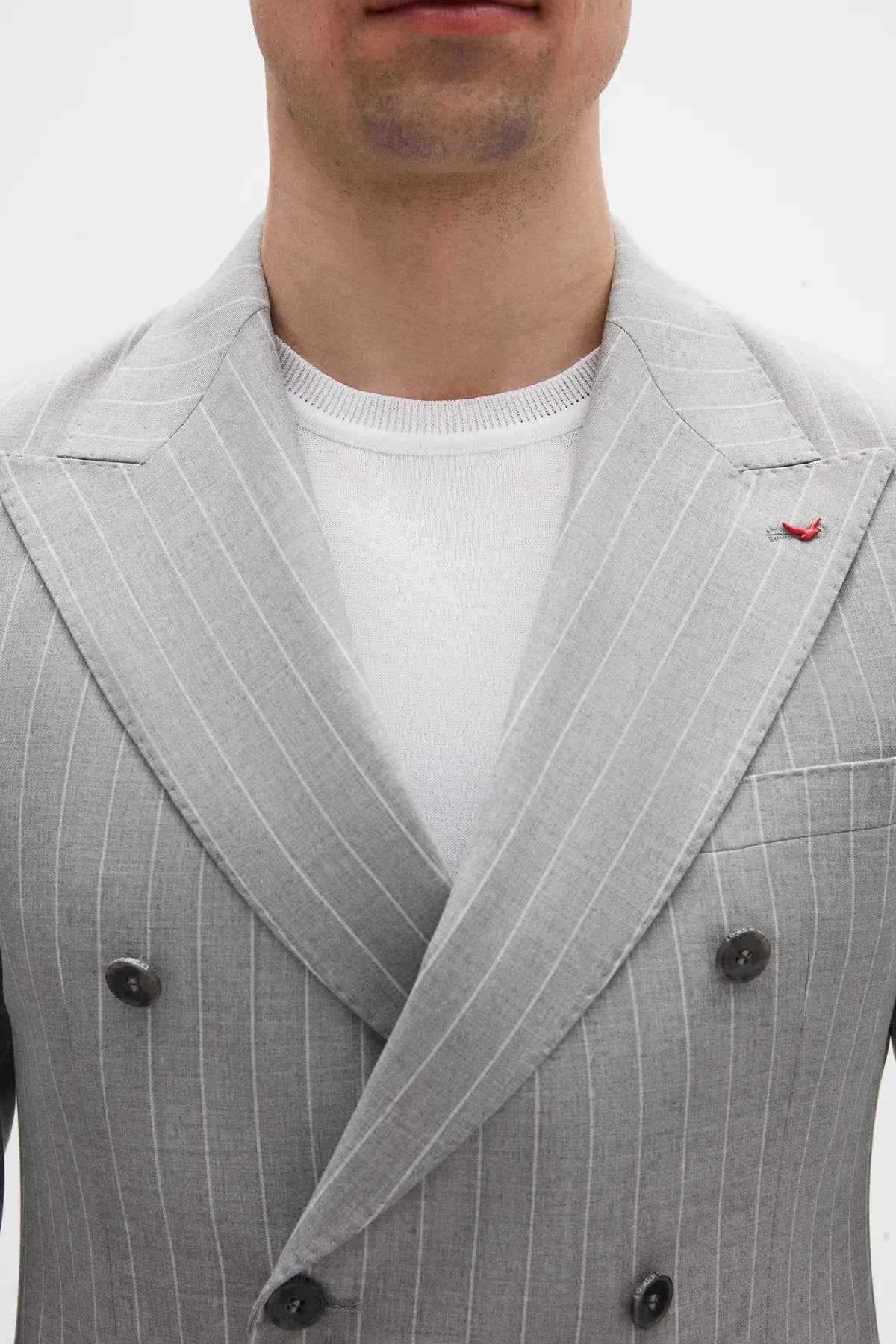 Men's gray striped suit jacket lapel with dark button detail