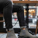 Gray suede ankle boots worn with dark jeans, thick lug sole and pull tab