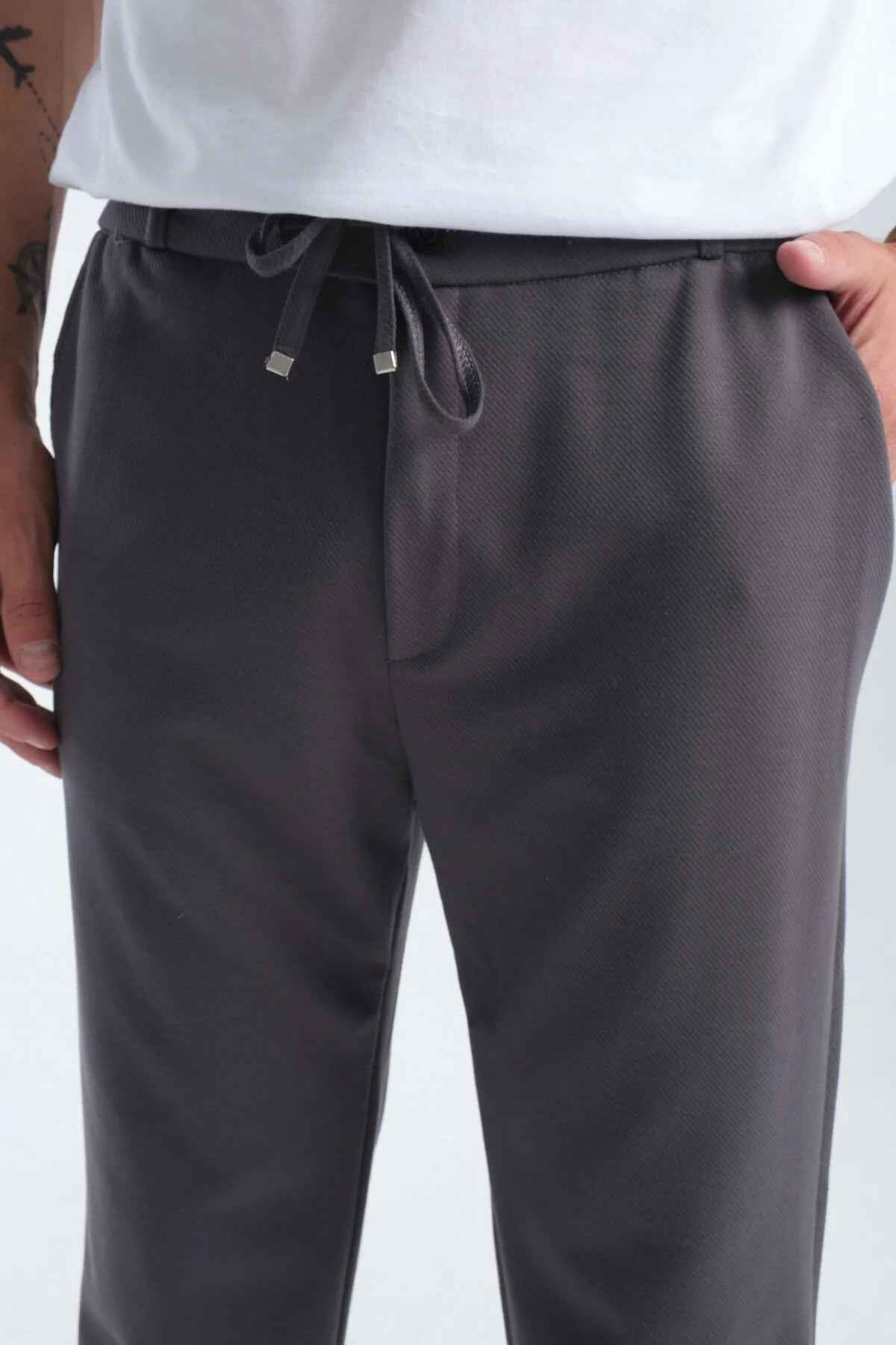 Men's gray sweatpants, close-up of drawstring waist and pocket seams