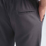 Men's gray sweatpants, back pocket and waistband hem close-up