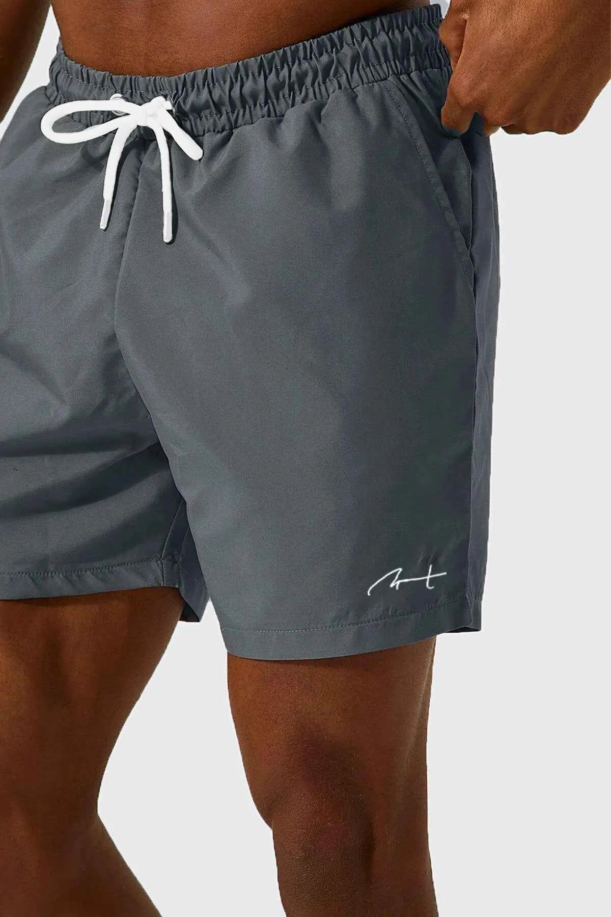 Men's gray swim shorts close-up of drawstring and elastic waist, side logo