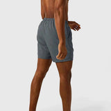 Men's gray swim shorts side view with elastic waistband and drawstring, logo patch