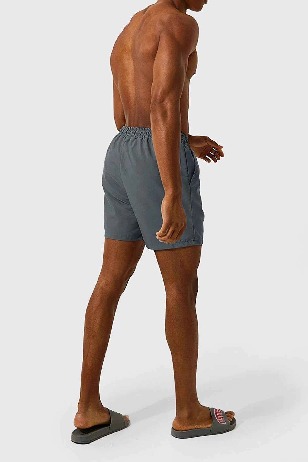 Men's gray swim shorts side view with elastic waistband and drawstring, logo patch