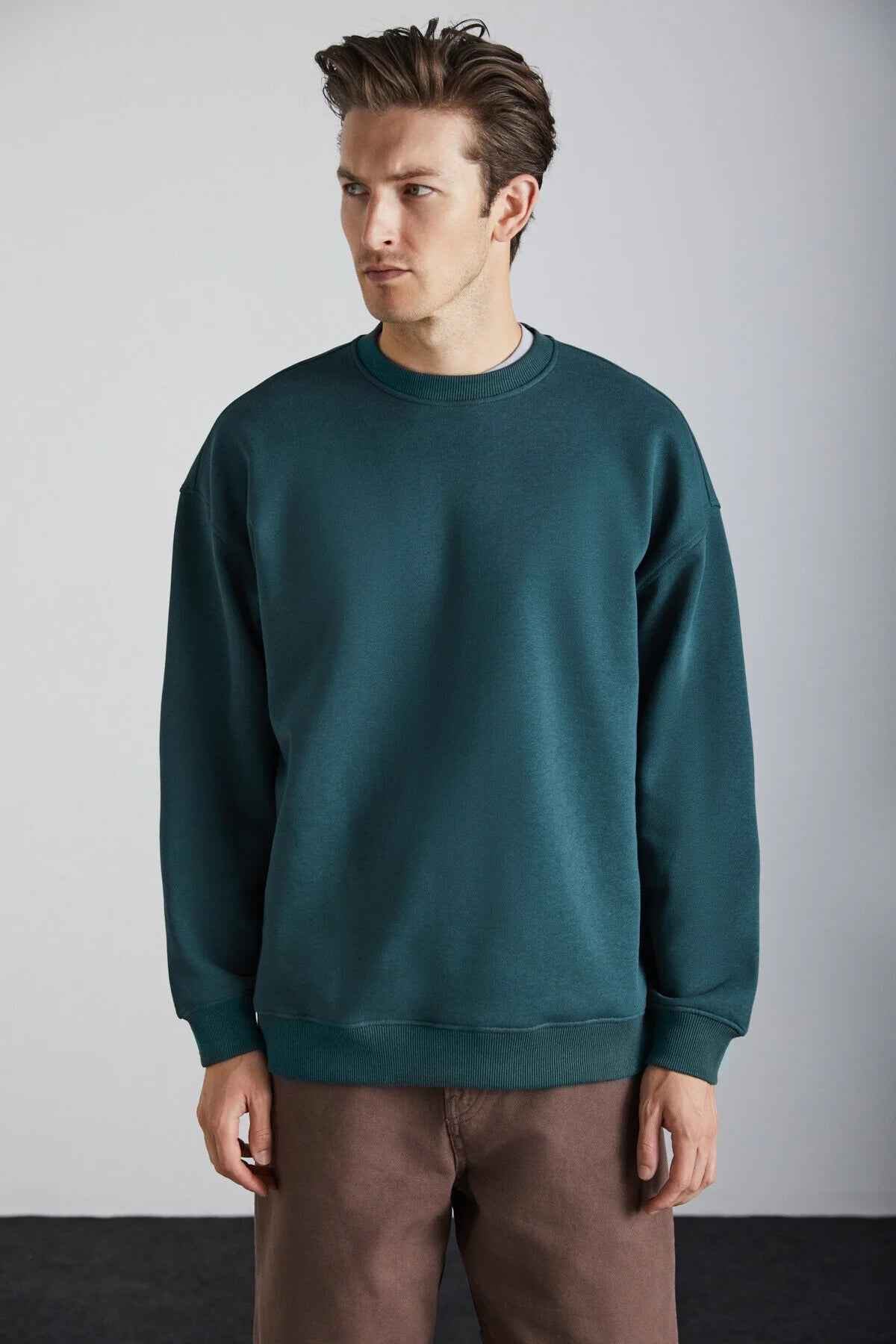 Dark green oversized crewneck sweatshirt with relaxed fit and ribbed cuffs