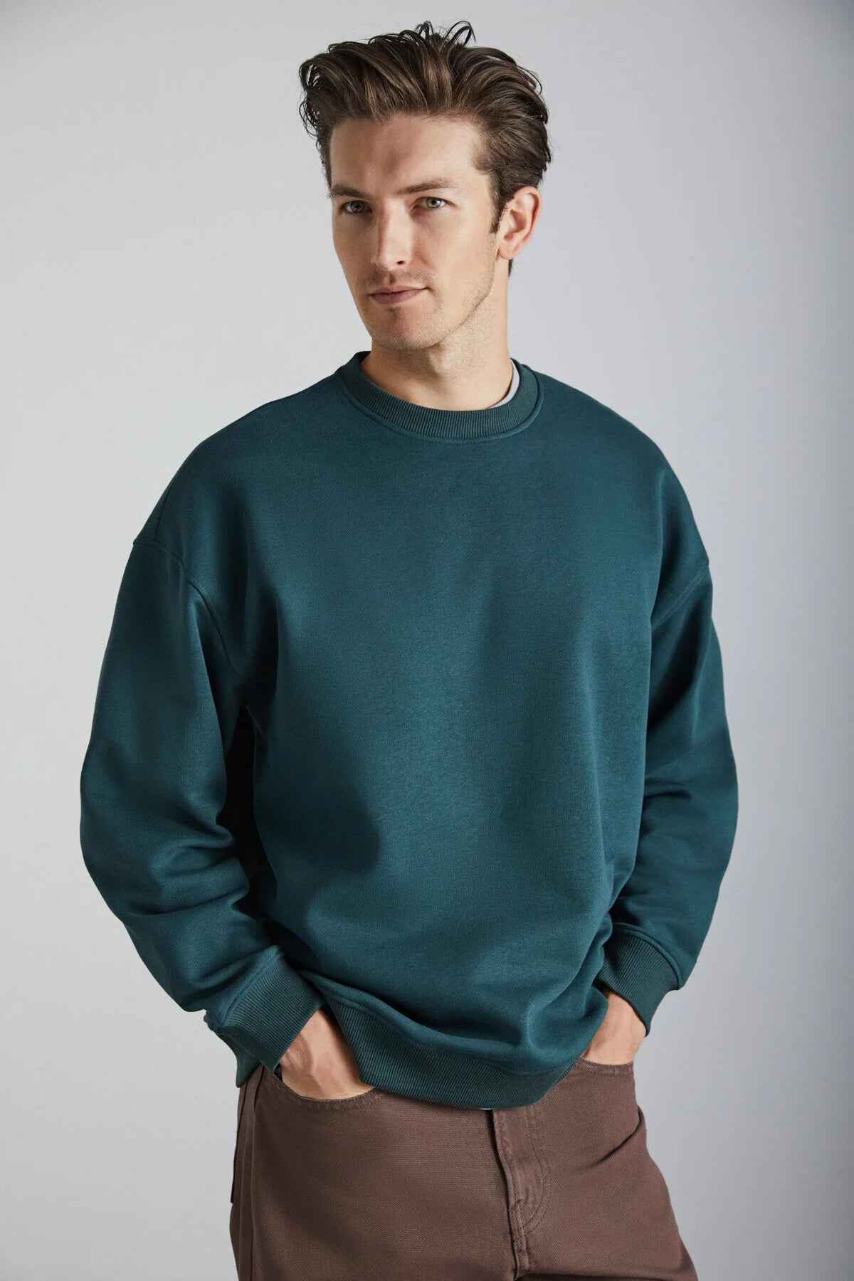 Dark green oversized crewneck sweatshirt, long sleeves with ribbed cuffs and hem