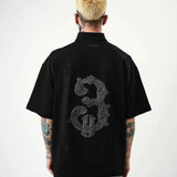 Black oversize men’s half-zip T-shirt with back embroidered guitar and dragon graphic