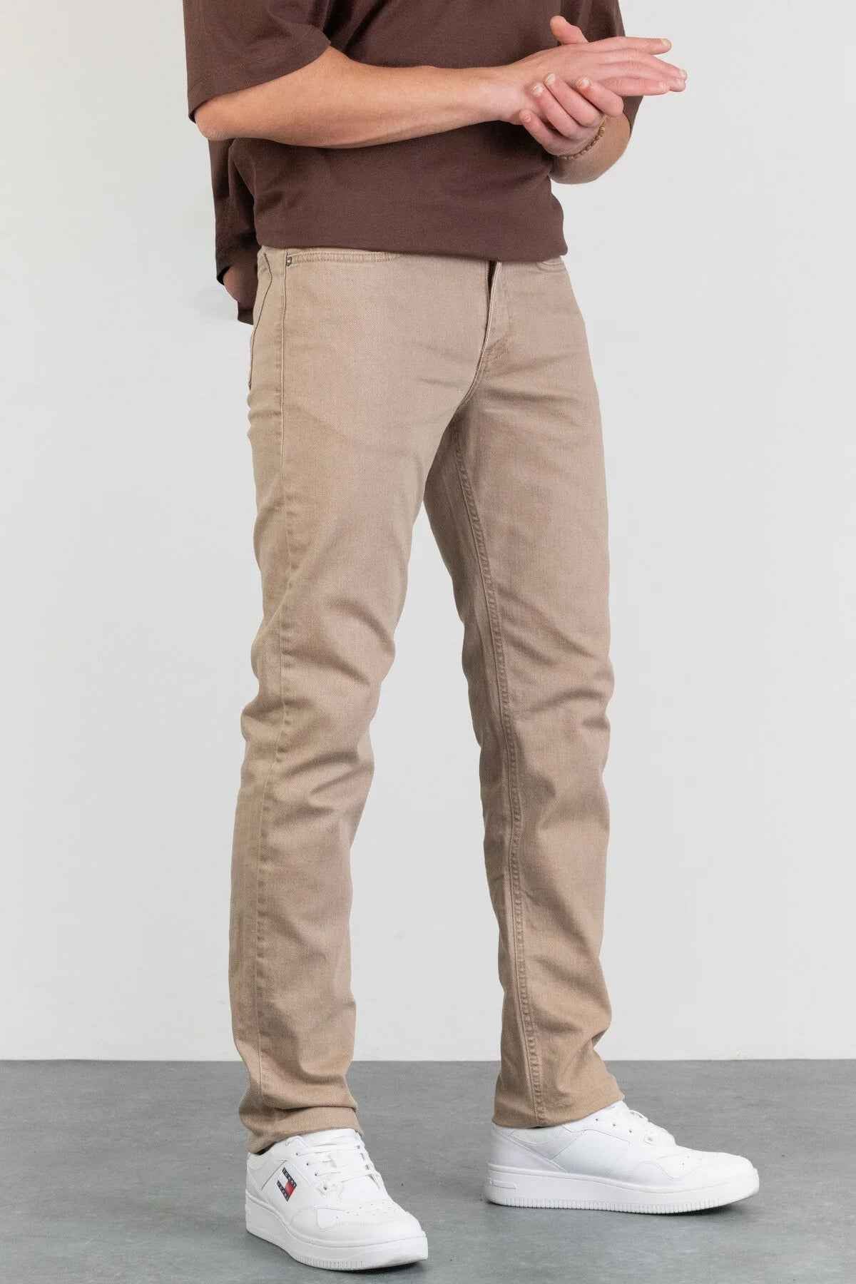 Men's beige jeans with zip fly, front pockets, and slim straight legs