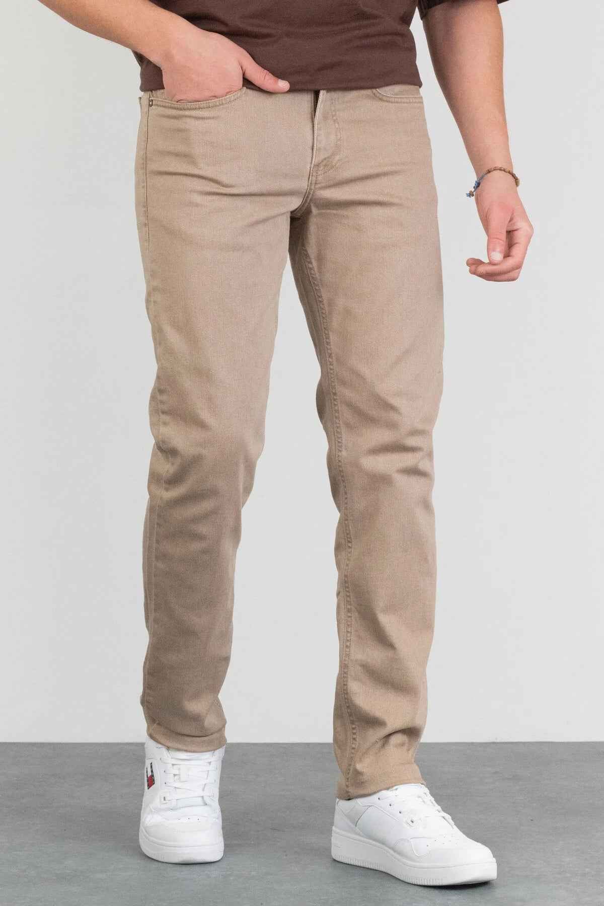 Men's beige jeans with front pockets, belt loops, and tapered ankle opening