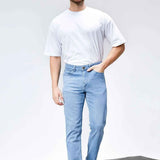Light blue slim jeans with five-pocket design, button closure, and belt loops