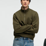 Olive zip stand-collar sweatshirt, relaxed fit, crossed-arms front view