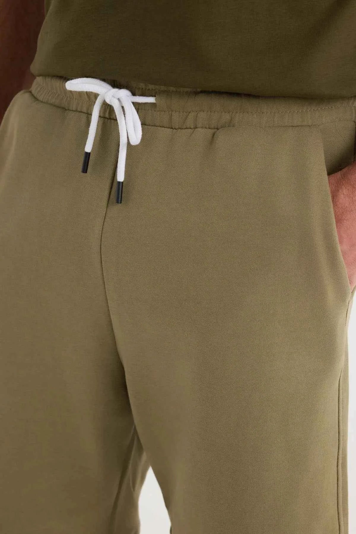 Men's olive khaki shorts waistband with white drawstring and elastic seam