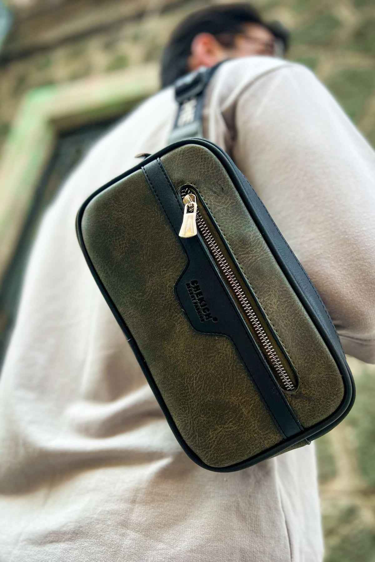 Khaki tablet bag worn crossbody, front vertical zipper pocket and tassel pull