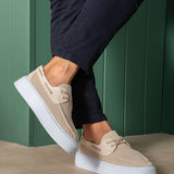 Beige knit lace-up sneakers with white sole, angled profile