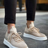 Beige knit sneakers with lace-up top and white sole, angled front view