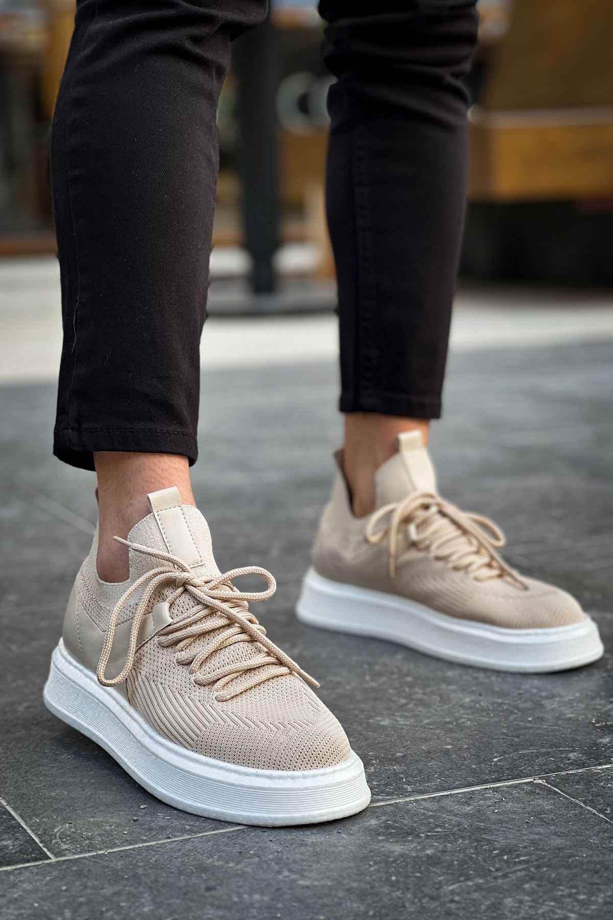 Beige knit sneakers with lace-up top and white sole, angled front view