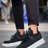 Black knit lace-up sneakers with white rubber sole, side view.