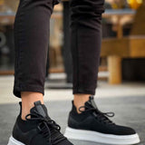 Black knit lace-up sneakers with white sole, side profile.