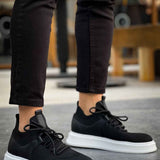 Black knit lace-up sneakers with white sole, front angle.
