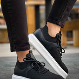 Black knit lace-up sneakers with white sole, close side view.