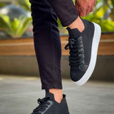 Men's black knit sneakers with lace-up front and white sole, walking pose