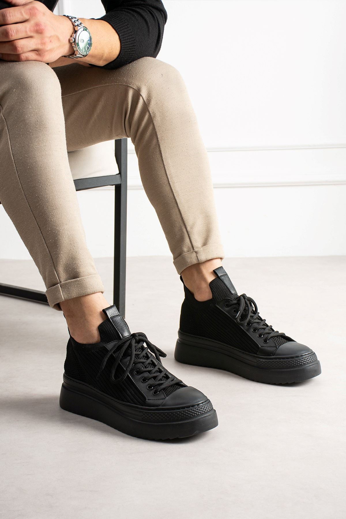 Black knit lace-up sneakers with low-profile rubber sole and padded heel