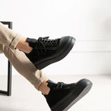 Black knit sneakers with chunky outsole, lace-up front, and ankle collar