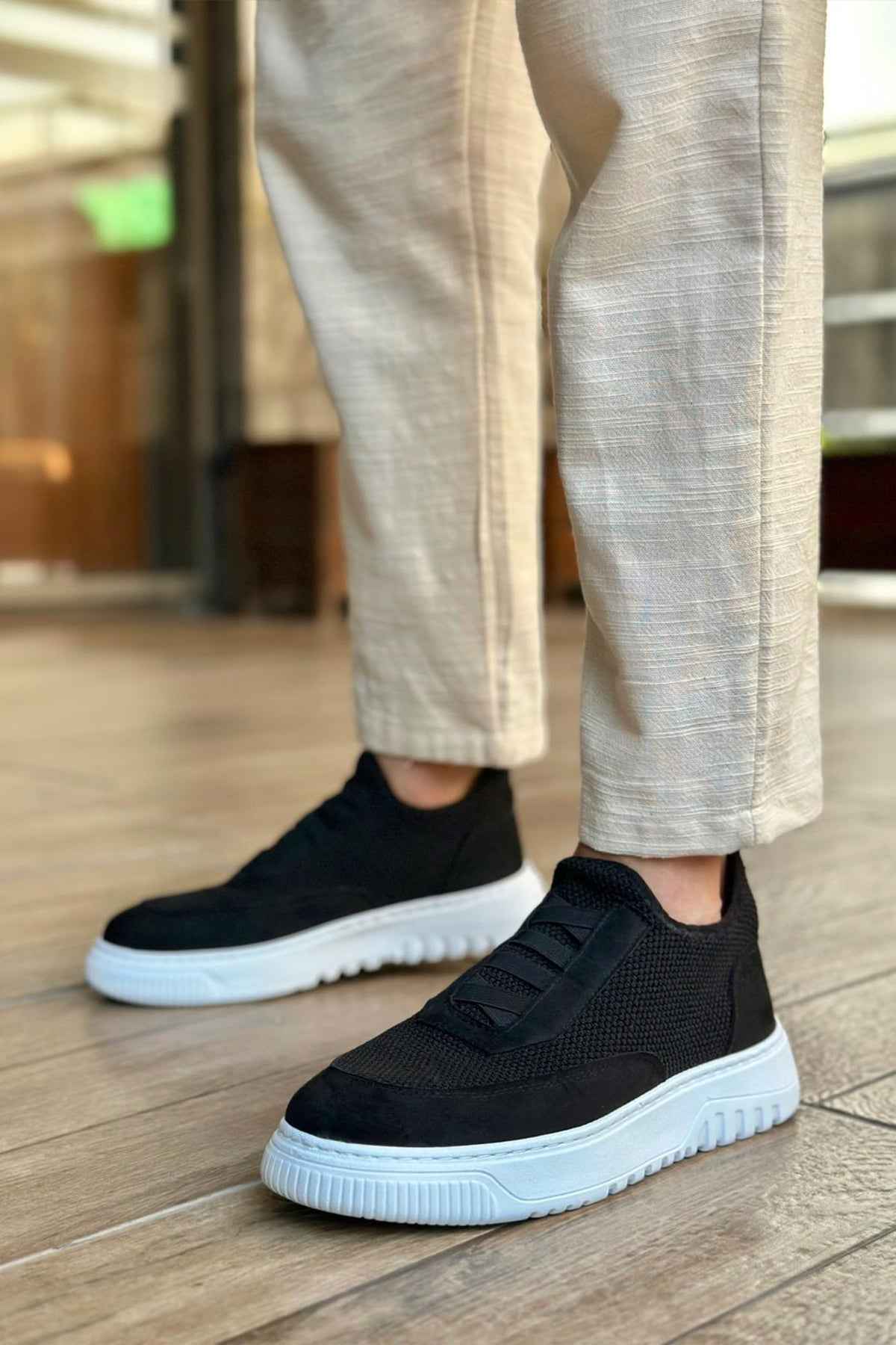 Men's black knit low-top sneakers with side strap detail and white rubber sole
