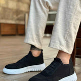Men's black knit low-top sneakers with white rubber sole and side stitching detail