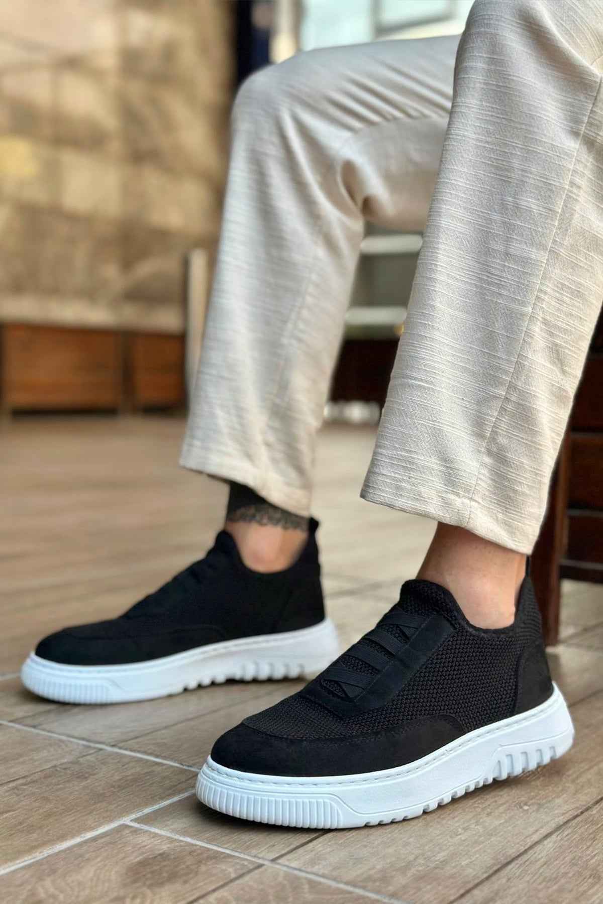 Men's black knit low-top sneakers with white rubber sole and side stitching detail