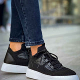 Knit black sneakers with lace-up front, white rubber sole, and side panel design