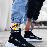 Black knit sneakers with white chunky sole and Velcro strap across the upper