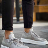Light gray knit sneakers, lace-up front view with white soles