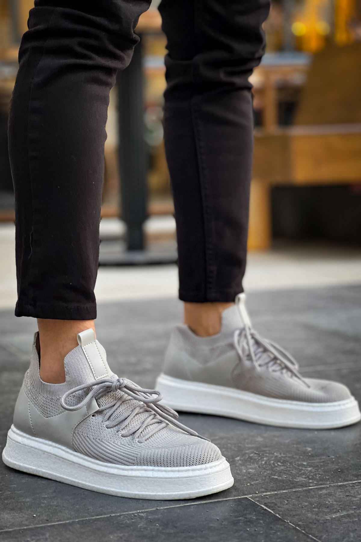 Light gray knit sneakers, lace-up front view with white soles