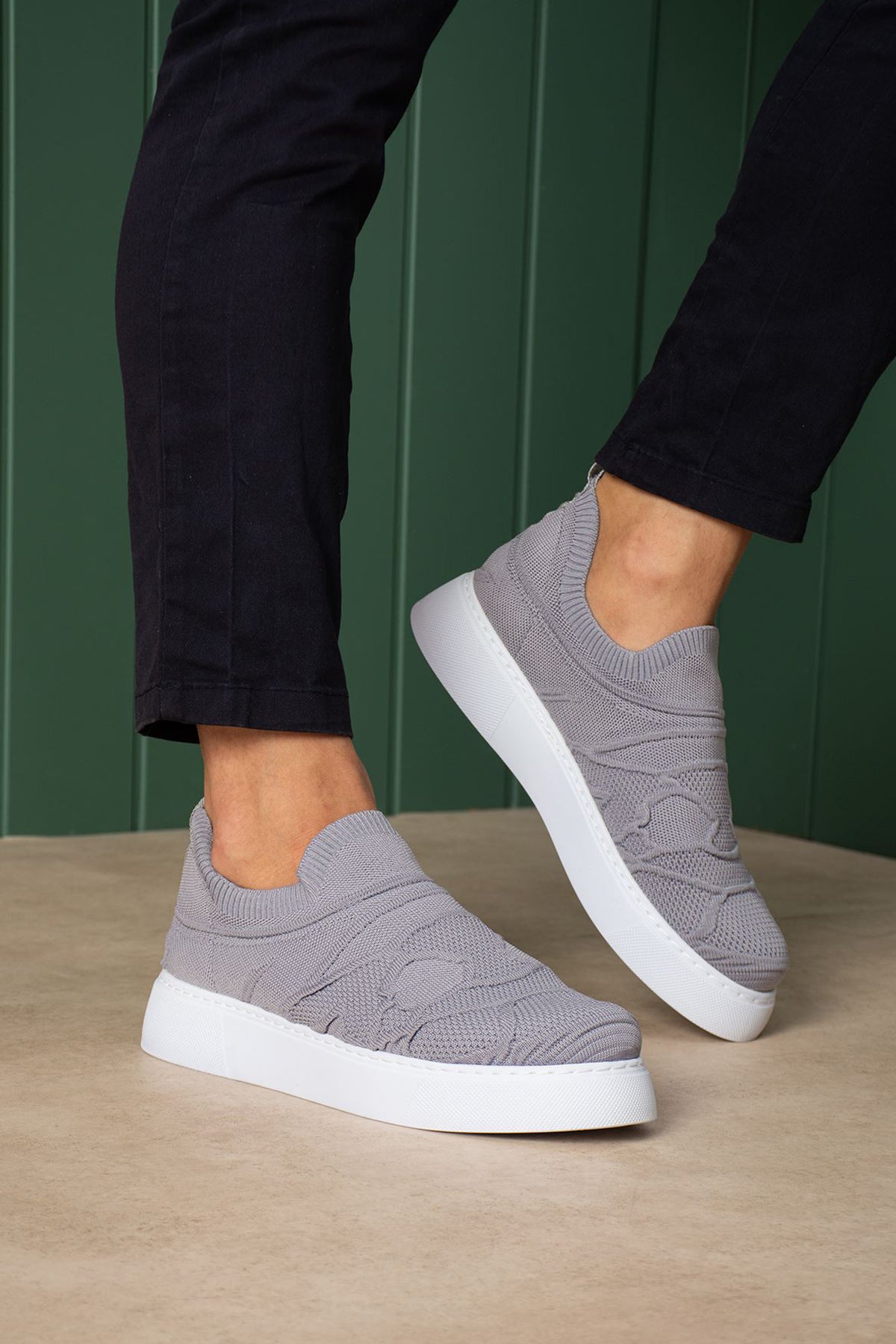 Gray knit slip-on sneakers with white rubber sole, side view