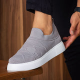 Gray knit sneakers with white sole and textured upper, angled side view