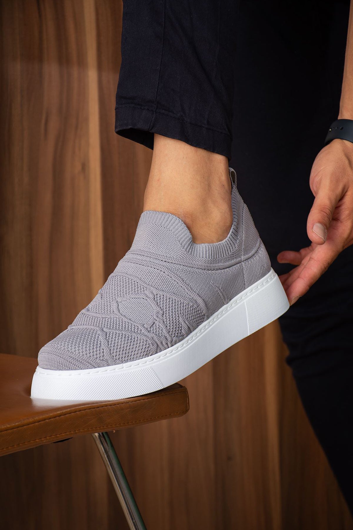 Gray knit sneakers with white sole and textured upper, angled side view