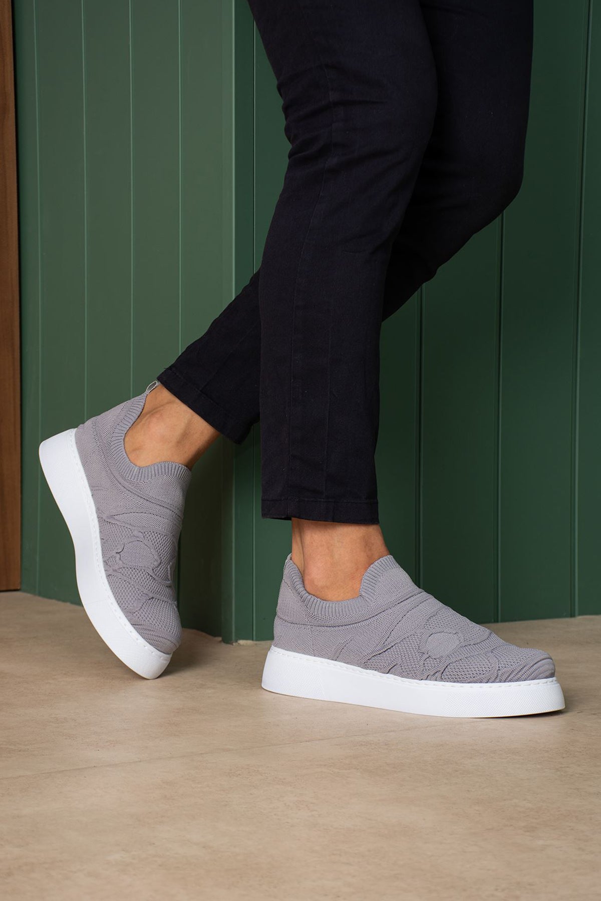 Gray knit slip-on sneakers with white sole, front three-quarter view